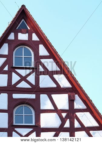 Gable and façade details of an old timber frame medieval house with white render and red beams in Nuermberg 2016