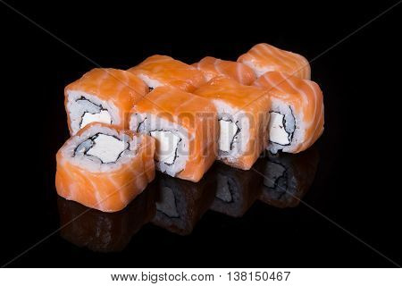 Philadelphia roll with salmon and cheese on a black background