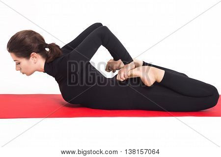 Beautiful athletic girl in a black suit doing yoga. bhekasana asana -frog pose . Isolated on white background.