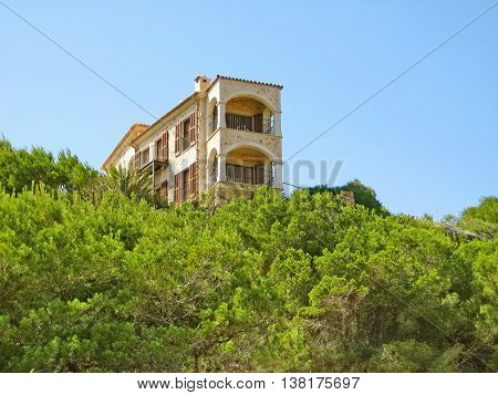 Apartment building / house accommodation view of balconies green trees / bushes in front blue sky