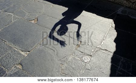ladies shadow on an ancient granite pavement