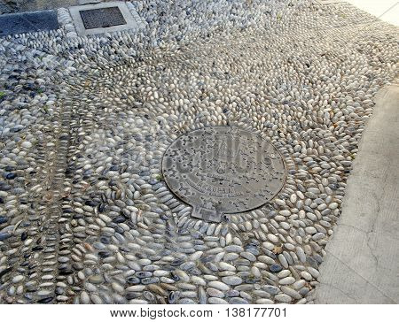 old water hatch and paving of sea pebbles