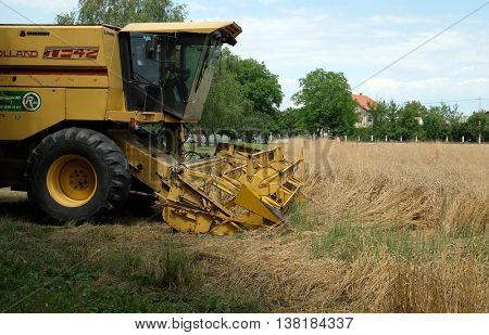 TRNOVEC, CROATIA - JULY 09, 2016: Combine harvester harvest ripe wheat on a farm in Trnovec, Croatia on July 09, 2016