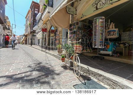 GREECE, ISLAND CRETE, RETHYMNON  - JULY 01, 2016: The tourist shop on the street of the old town of Rethymnon and the bicycle with flowers.