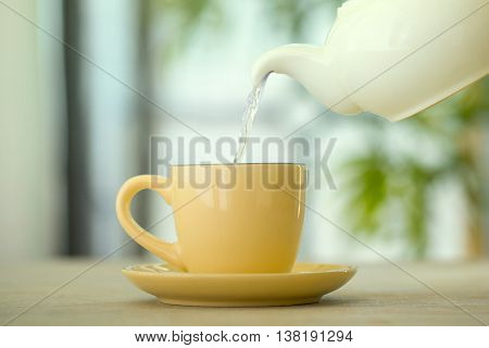 Side view of a male pouring tea