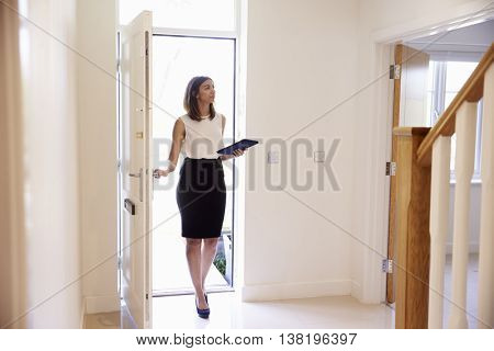 Female Realtor In Hallway Carrying Out Valuation