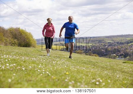 Mature Couple Jogging In Countryside