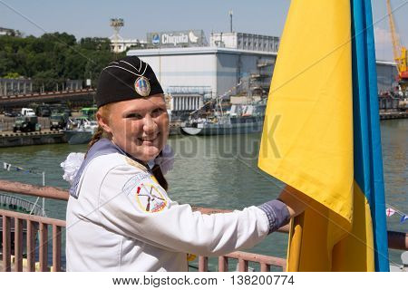 Odesa, Ukraine - July 03, 2016: red-haired girl with a flag of Ukraine in the navy uniform during celebration of Navy Day in Odessa