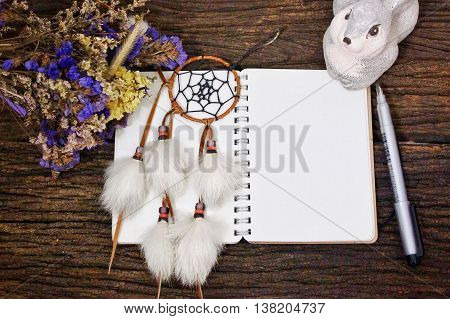 Dream catcher & blank notebook diary on wooden table