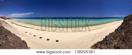 View to sandy beach with vulcanic mountains in the background near Costa Calma town on Fuerteventura island Canary Islands Spain.