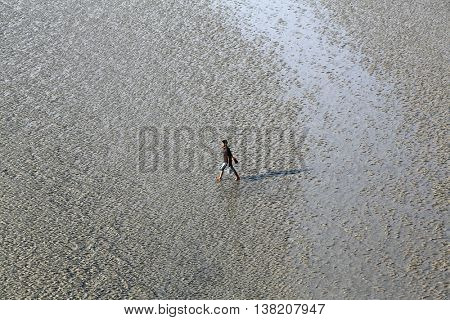 CANNING TOWN, WEST BENGAL, INDIA - FEBRUARY 13: During low tide the water in the river Malta falls so low that people walk to the other shore in Canning Town, India on February 13, 2014.