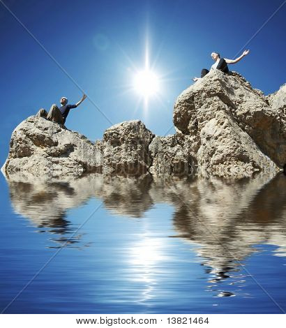 Niña y niño meditando sobre la roca