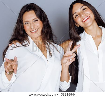 cute pretty teen daughter with mature mother hugging, fashion style brunette makeup close up, real happy family