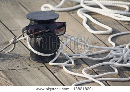 Mooring rope on the pier and sunglasses. Life style