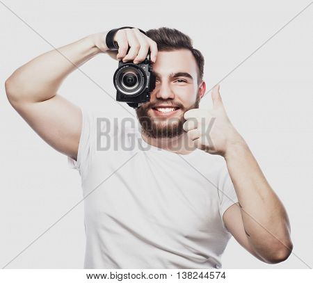 young bearded photographer taking pictures with digital camera.