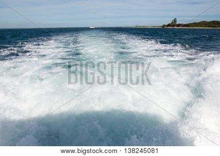 Foamy boat wake trailing in the Indian Ocean waters in Rockingham, Western Australia.