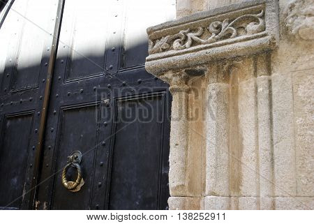 antique doors into the courtyard with a decorative column fragment