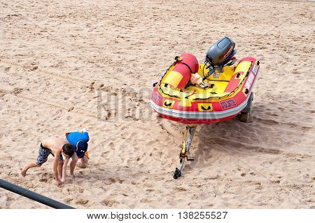 DURBAN SOUTH AFRICA - JULY 09 2016: Children playing on the beach near a surf rescue boat in Umhlanga Rocks