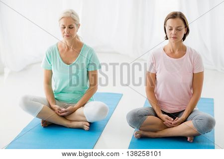 Full lenth of women performing yoga at fitness studio