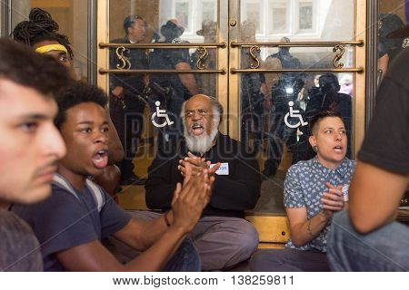 Black Lives Matter Protestors  Sit In Front Of An Entrance Of The City Hall