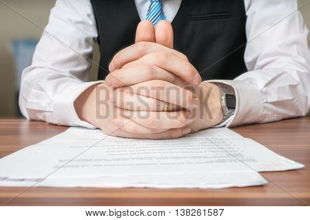 Negotiation With Lawyer Who Is Sitting Behind Desk And Has Clasp