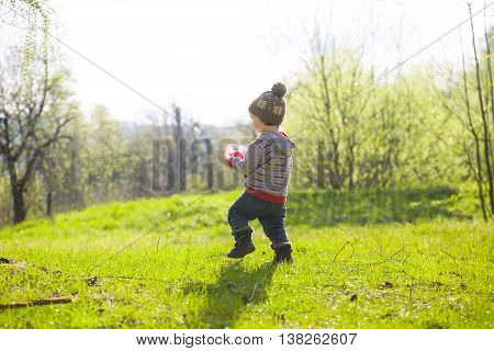 A Child Plays With A Frisbee Outdoors.