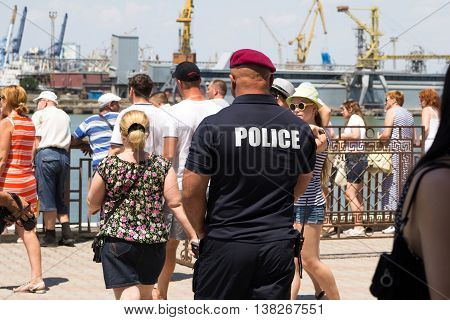 Odesa, Ukraine - July 03, 2016: Pumped police officer in red beret and with a large white inscription on the back 'Police'. Navy day celebration in Odesa