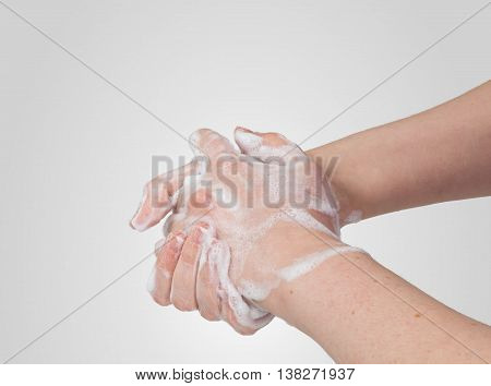 Washing or cleaning hands with soap on gray background.