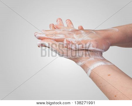 Washing or cleaning hands with soap on gray background.