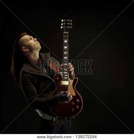 Guitarist playing rock music. On dark background. Beautiful guitar.