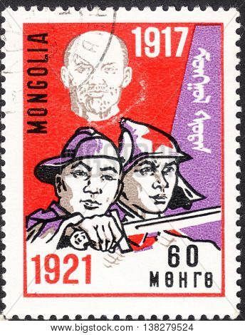 MOSCOW RUSSIA - JANUARY 2016: a post stamp printed in MONGOLIA shows soldiers of the national army the series "The 50th Anniversary of October Revolution" circa 1967