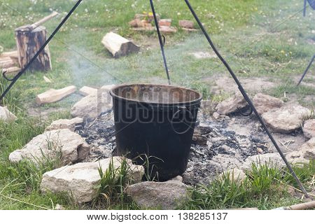 Pot water on the fire tourists kettle on hot campfire. Camping photo.