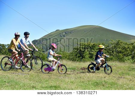 Parents with kids riding bikes in moutain path