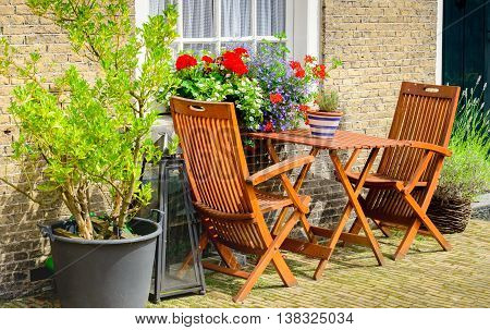 Two wooden chairs and a small tabel before the historic facades of the Begijnhof in the Dutch city of Breda.