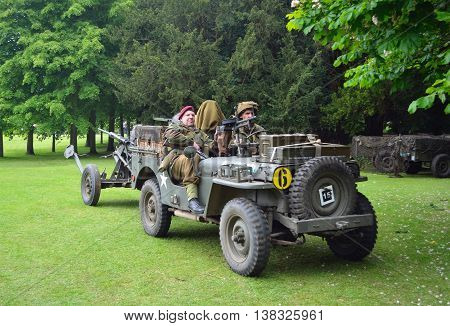 Silsoe, Bedfordshire, England - May 30, 2016: World War 2 Jeep with men dressed as World War 2 Soldiers, towing Gun.