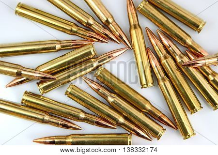 pile of rifle cartridges on a white background