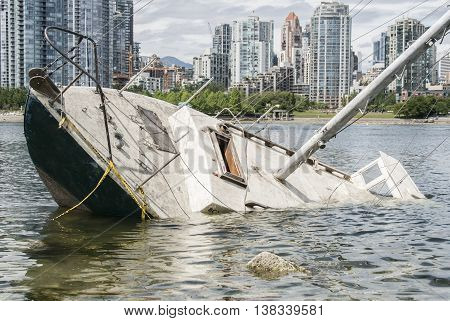 Sinking sailboat abandoned on the shore of a city