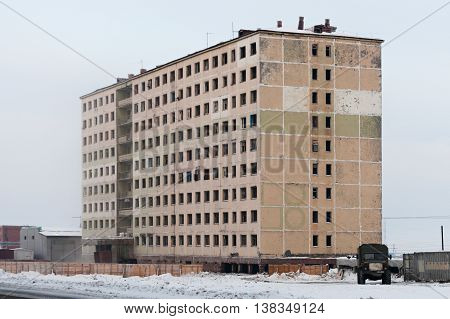 Derelict high-rise building in Norilsk. House on pile foundation, built on permafrost.