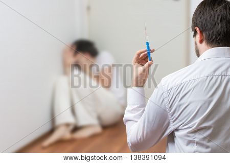 Psychiatrist Doctor Holds Syringe. Crazy Or Insane Patient In Ba