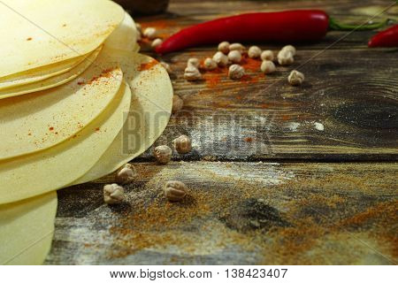 Colorful Indian food - papadum chickpea gram flour and spices on textured wooden table top