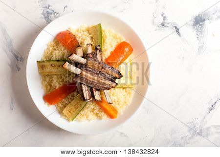 Traditional couscous dish with lamb ribs and vegetables. Top view. The image contains a copy space for your text