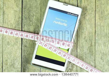 BUNG KAN THAILAND - FEBRUARY 21 2016: smart phone display runtastic app and measure tape on office desk