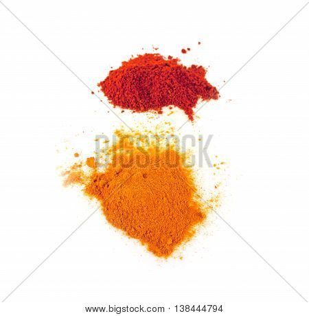 Turmeric (Curcuma) Powder and Pile of red paprika powder isolated on white background