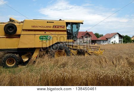 TRNOVEC, CROATIA - JULY 09, 2016: Combine harvester harvest ripe wheat on a farm in Trnovec, Croatia on July 09, 2016