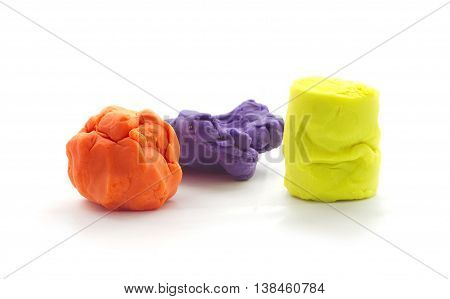 Three Modelling clay balls of different colors isolated on a white background