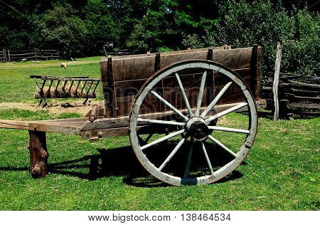 Sleepy Hollow NY - July 9 2009: A wooden hay cart with large spoked wheels at the c. 1750 Philipsburg Manor farm