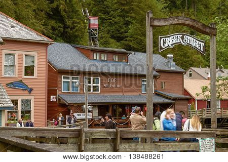 KETCHIKAN ALASKA USA - MAY 29 2011: People Looking for Salmon and Photographing while Enjoying Visit of Creek Street in Ketchikan Alaska.