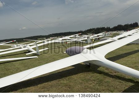 gliders at green airfield with blue sky