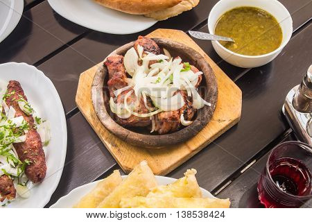 Delicious beautifully served barbecue sauce near khachapuri and lemonade on a stylish black wooden table