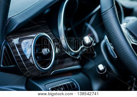 Luxury car interior details. Air deflector and steering wheel